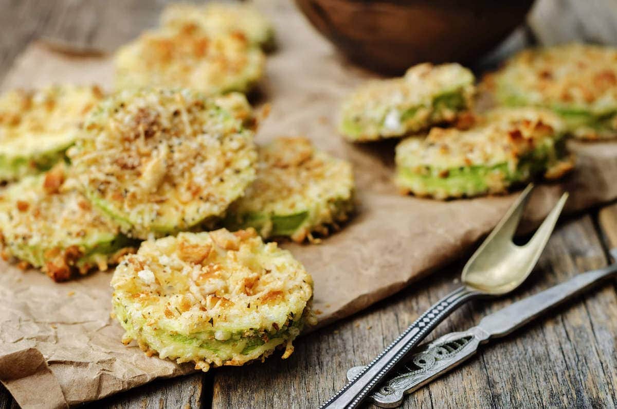 crispy breaded and fried zucchini chips on top of parchment paper