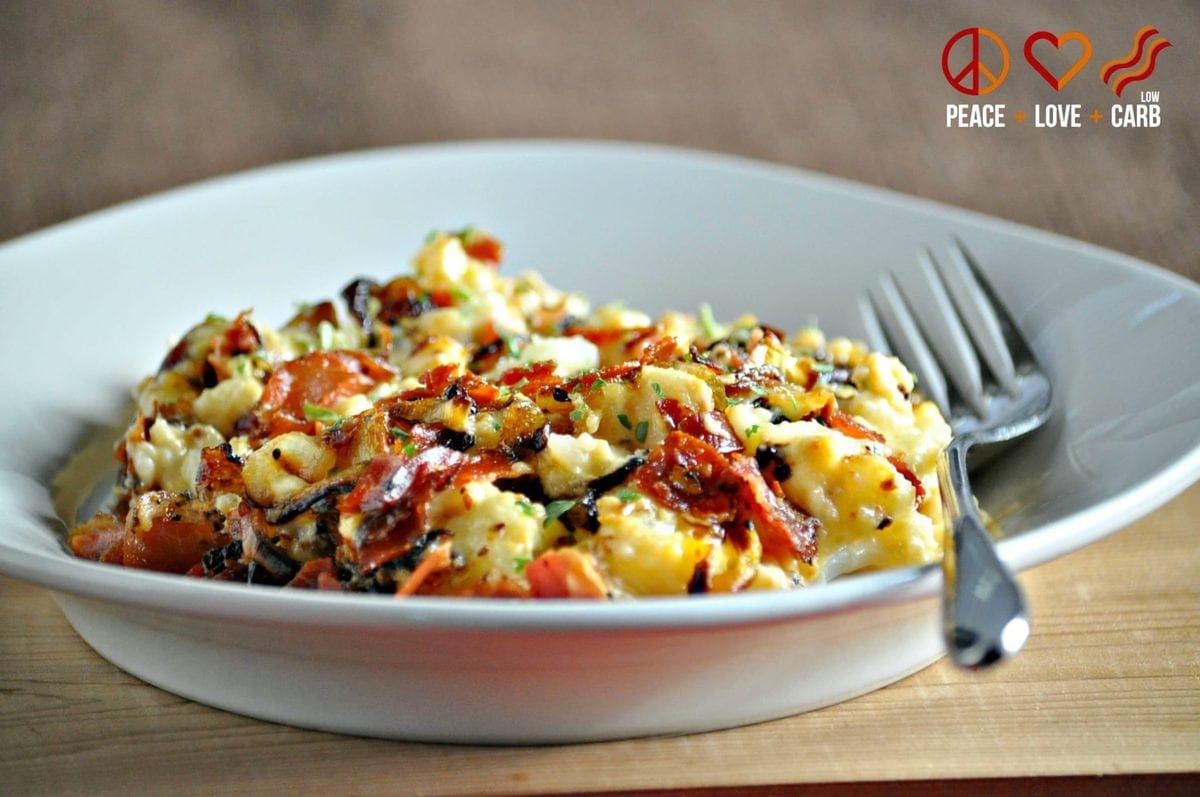 a bowl of keto Mac and cheese, made with cauliflower and topped with cheese, crispy prosciutto, and caramelized onion