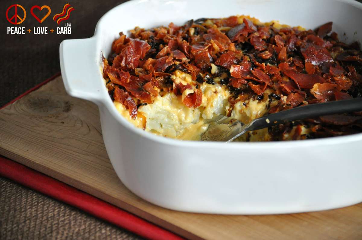 a bowl of keto Mac and cheese, made with cauliflower and topped with cheese, crispy prosciutto, and caramelized onion