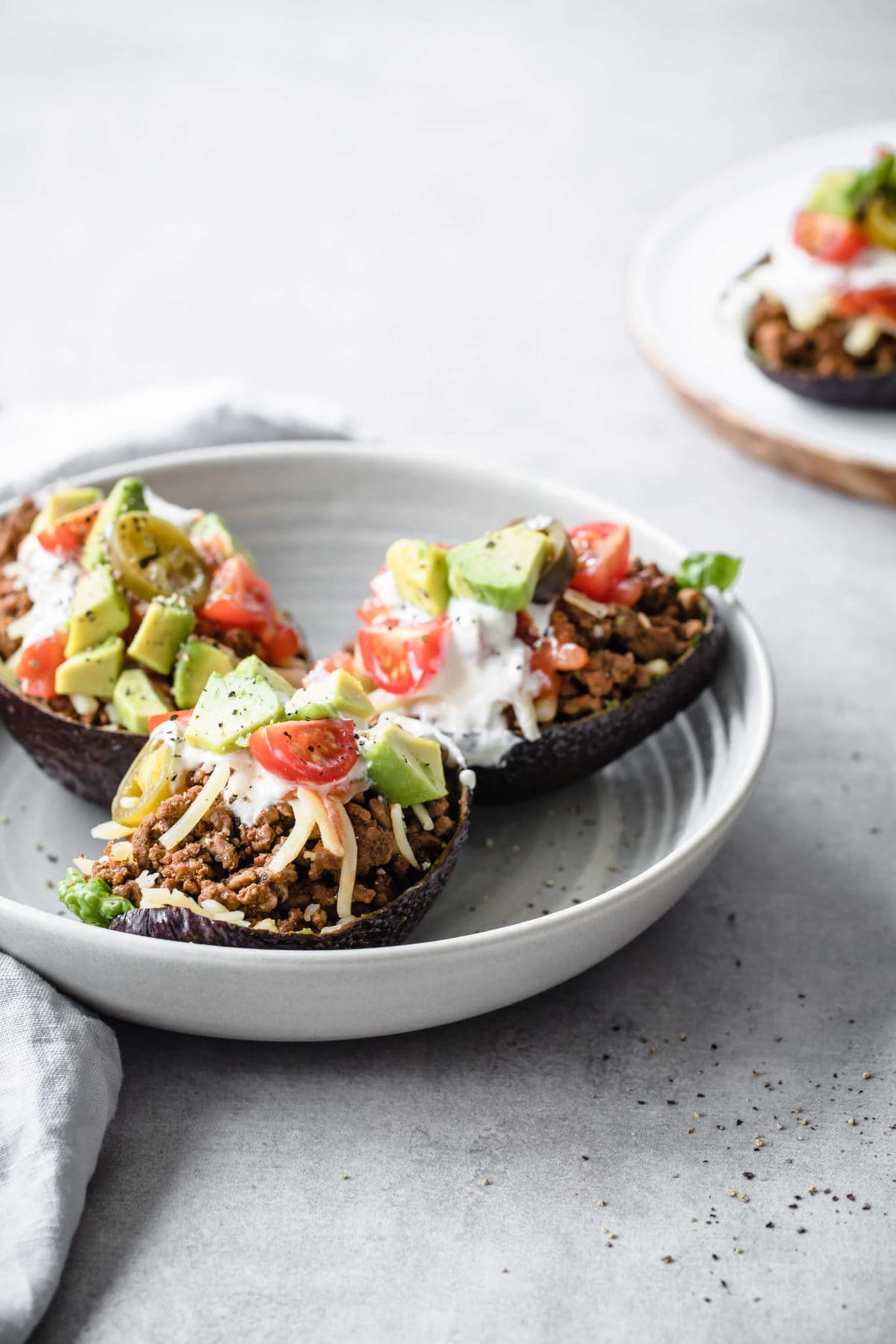 tacos served in an avocado shell with ground beef, cheese, tomatoes, avocado and sour cream 