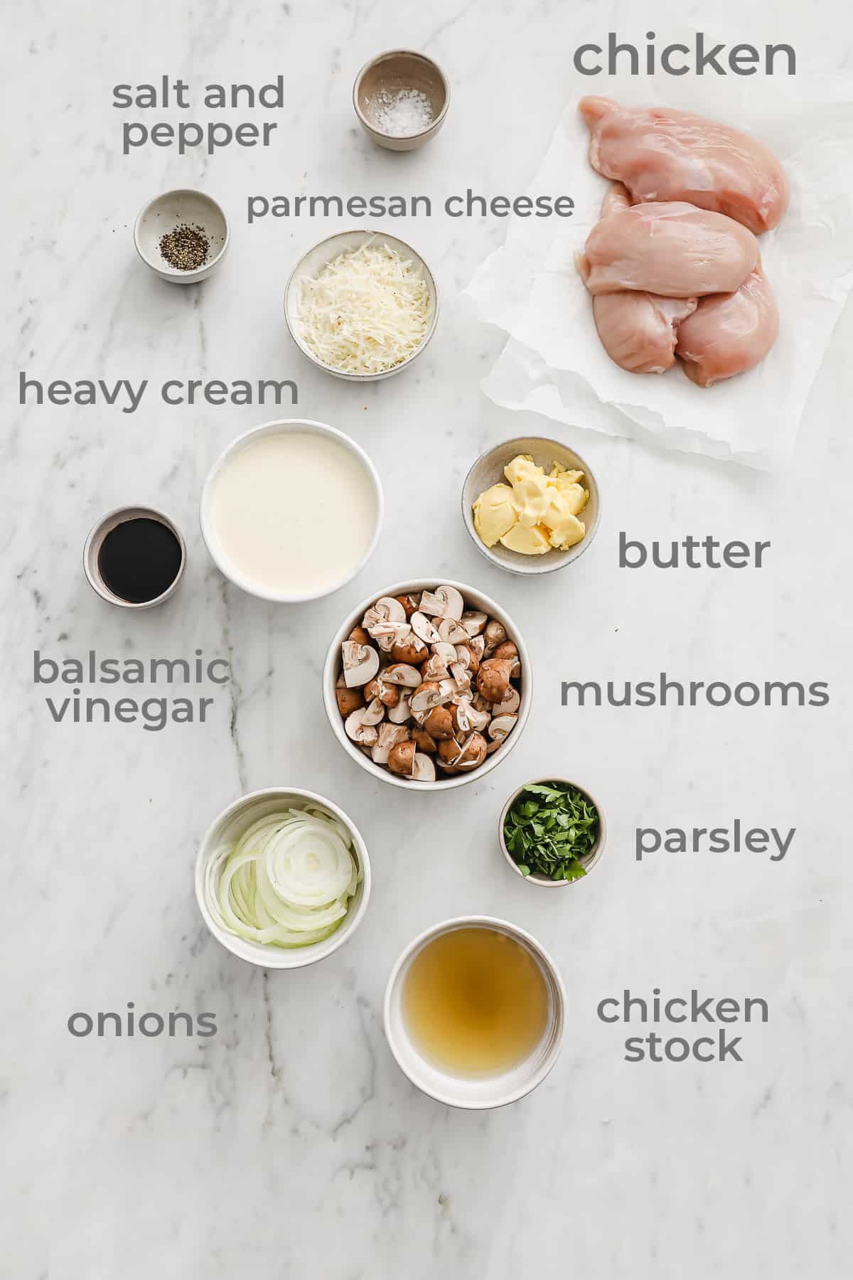 ingredients laid out to make a low carb chicken dish - chicken, onion, mushroom, cheese, cream, vinegar, salt, and pepper