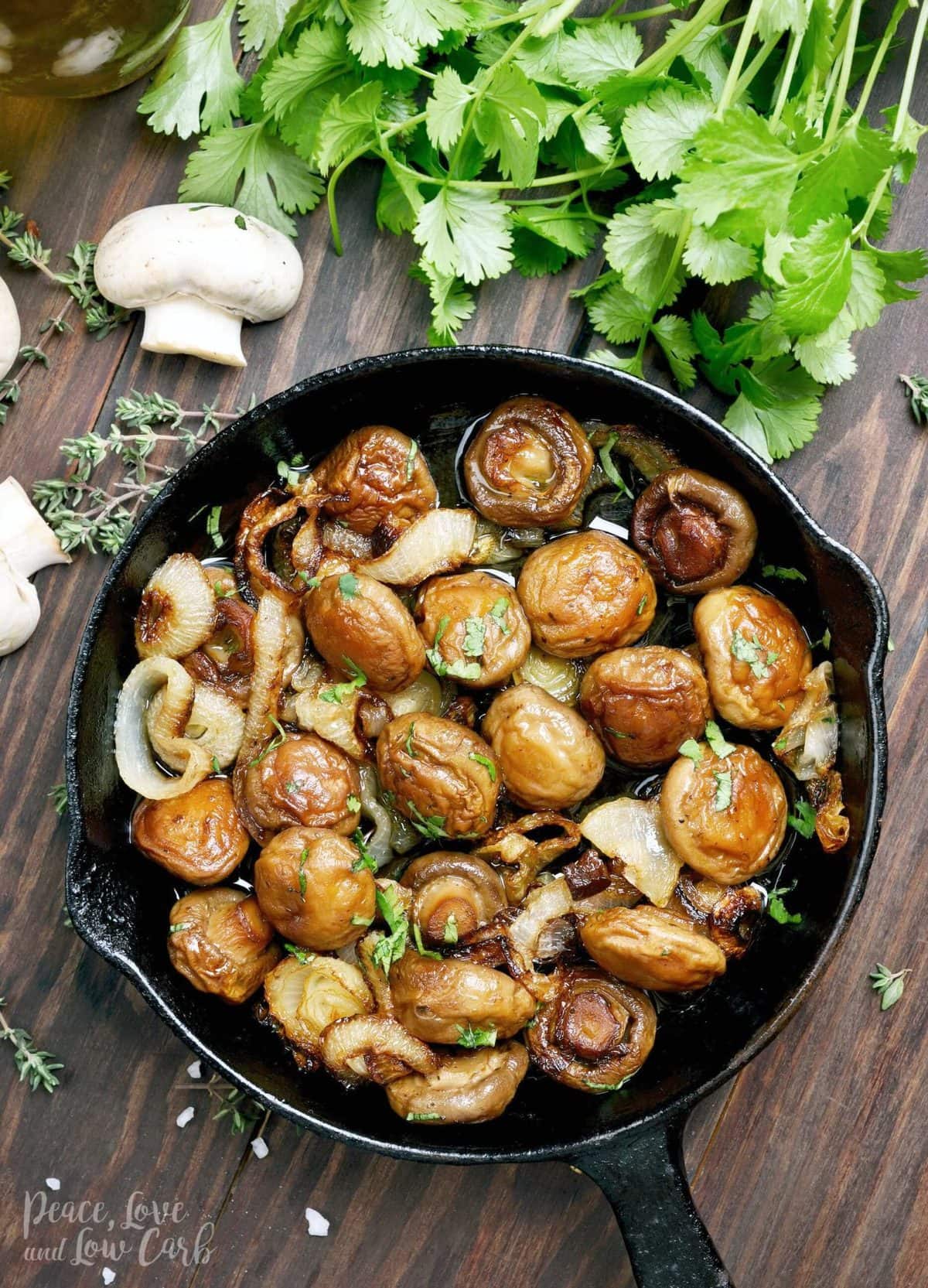 A cast iron skillet full of sautéed mushrooms and onions, garnished with parsley