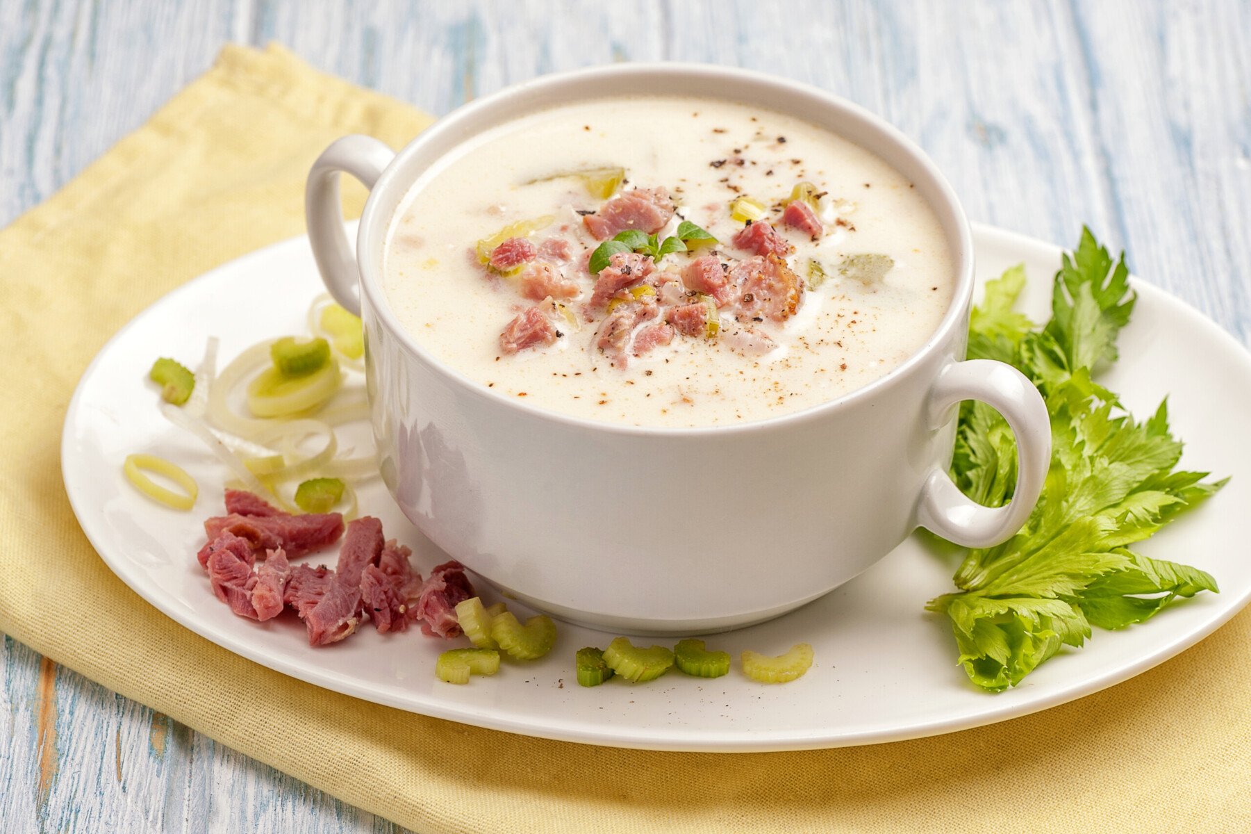 bowl of creamy reuben soup, garnished with green onion, sauerkraut and corned beef