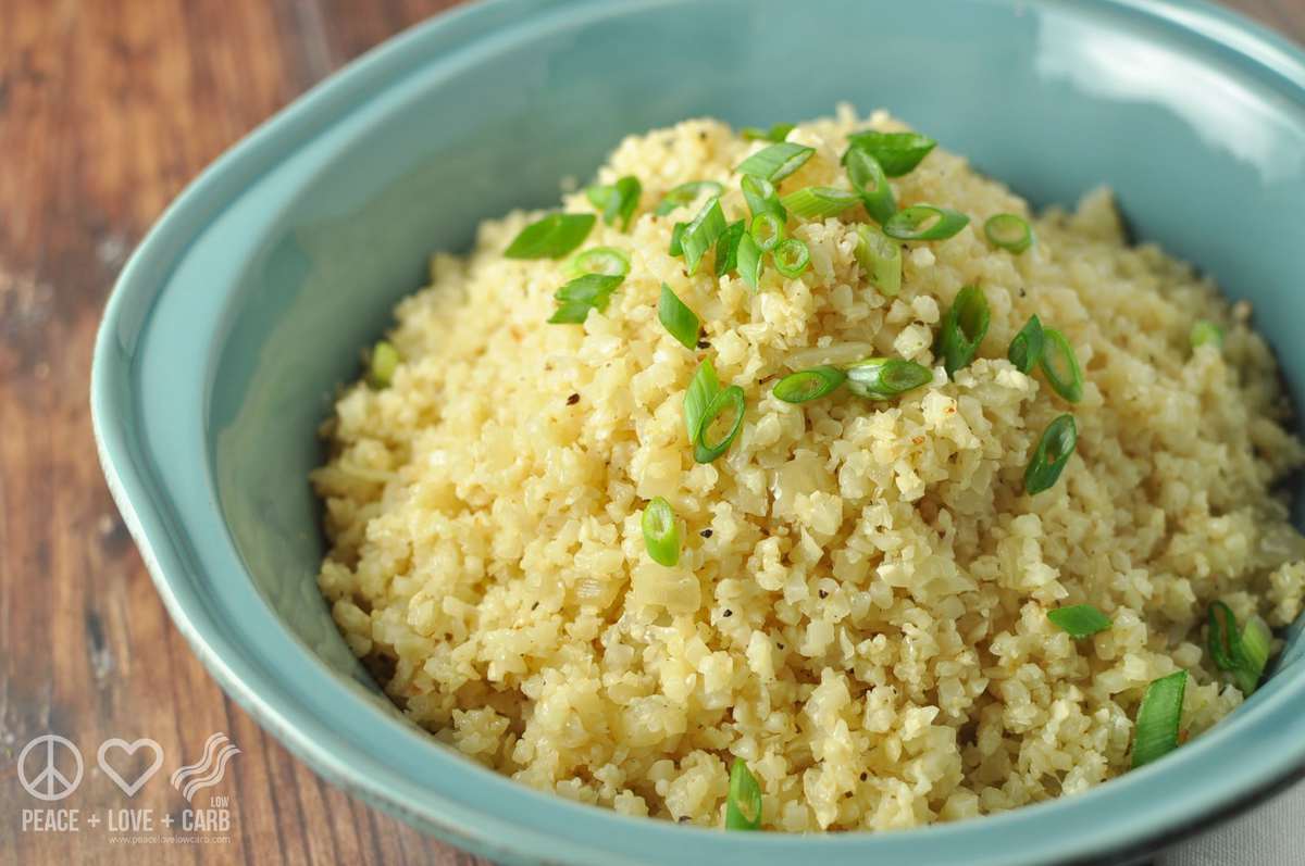 a blue serving dish with cauliflower rice served in it, topped with green onions