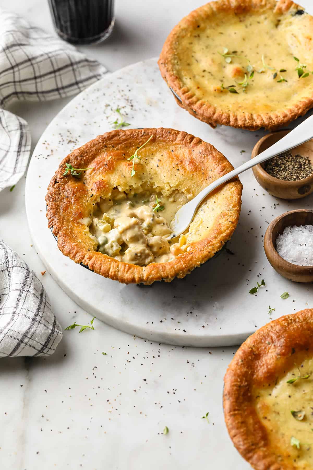 a personal sized chicken pot pie with a fork taking a bite out of it