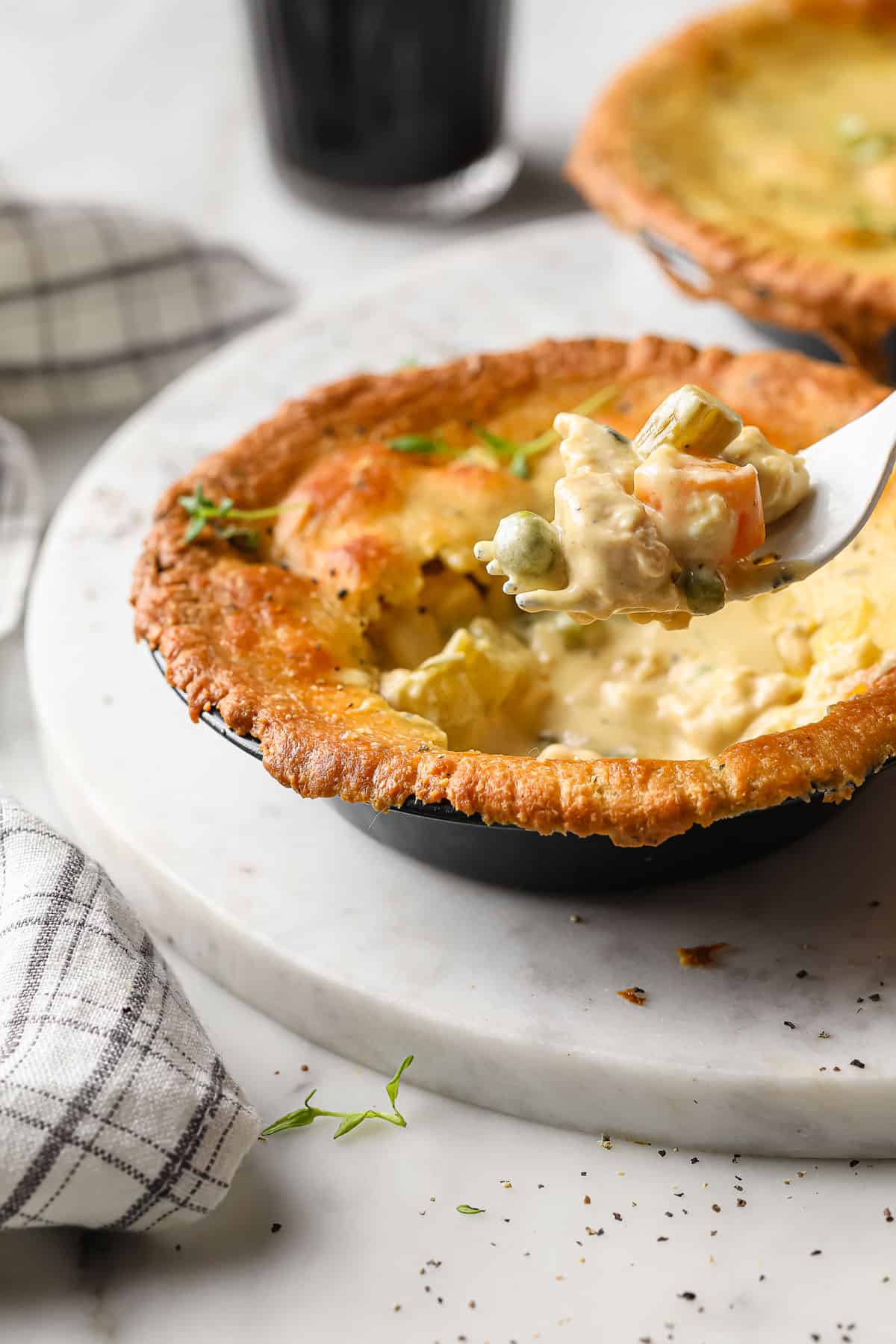 a  personal sized chicken pot pie with a fork taking a bite out of it