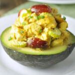 Curried Chicken Salad Stuffed Avocados, the perfect Whole30 lunch. Filling, with a bit of a kick, sweetness from grapes, and crunch from cashews.