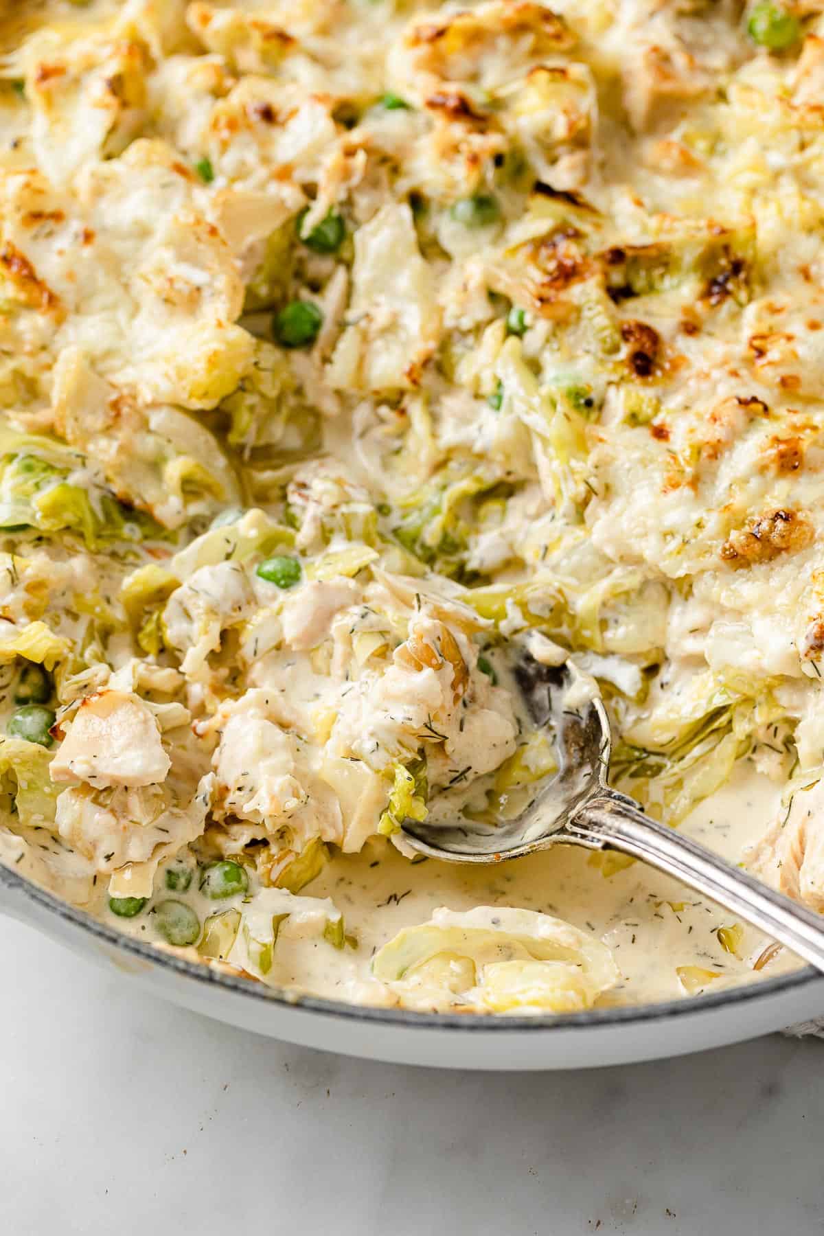 a skillet full of low carb tuna casserole, rich and creamy sauce, baked golden brown with cheese