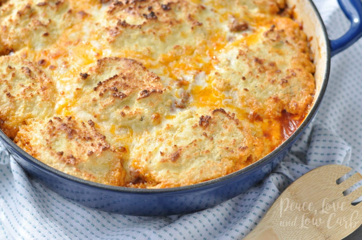 Overhead shot of a chili dog pot pie casserole in an enameled cast iron skillet.