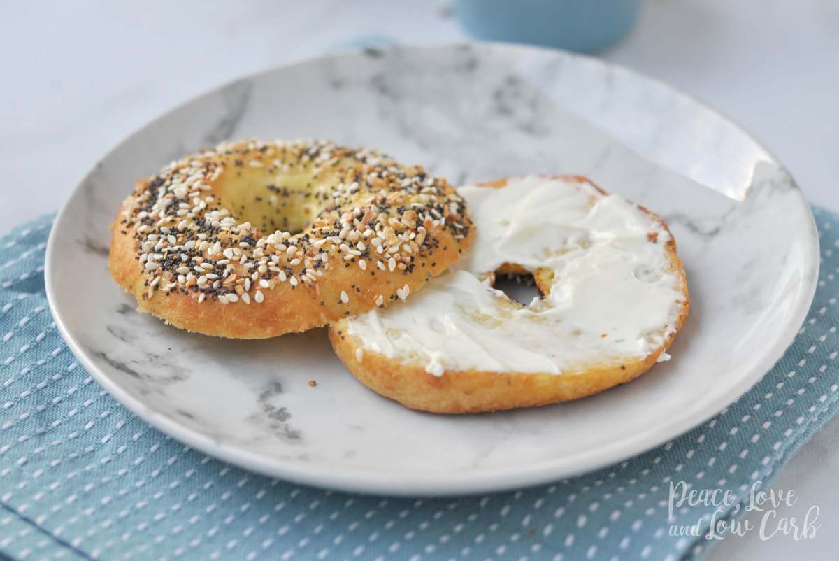 a low carb everything bagel cut in half and slathered with cream cheese. Served on a marble plate