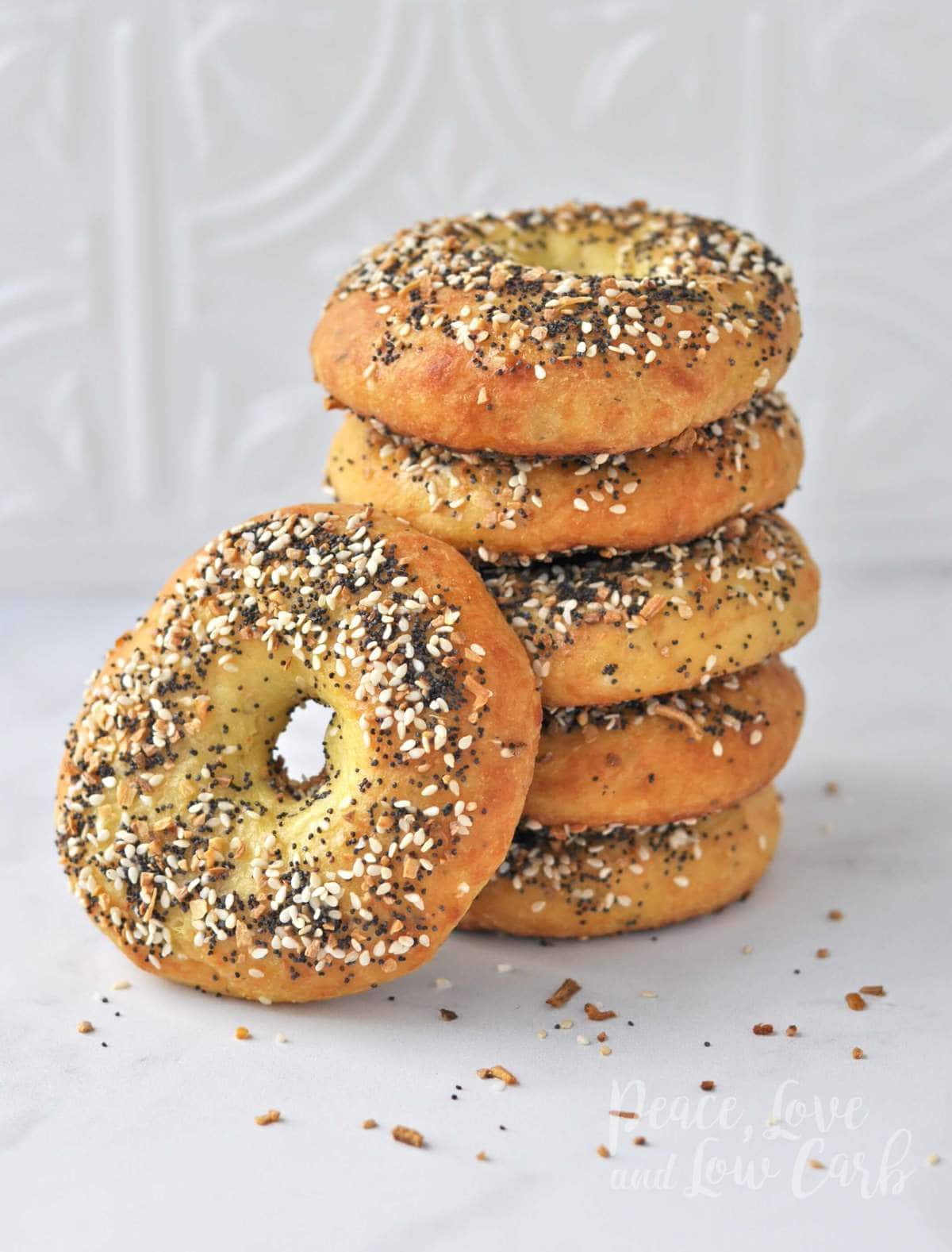 A stack of keto everything bagels with one bagel propped up on the stack