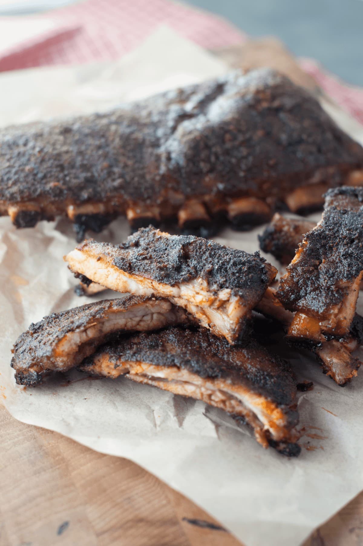 juicy, tender baby back spare ribs, seasoning with dry rub and piled high on parchment paper 