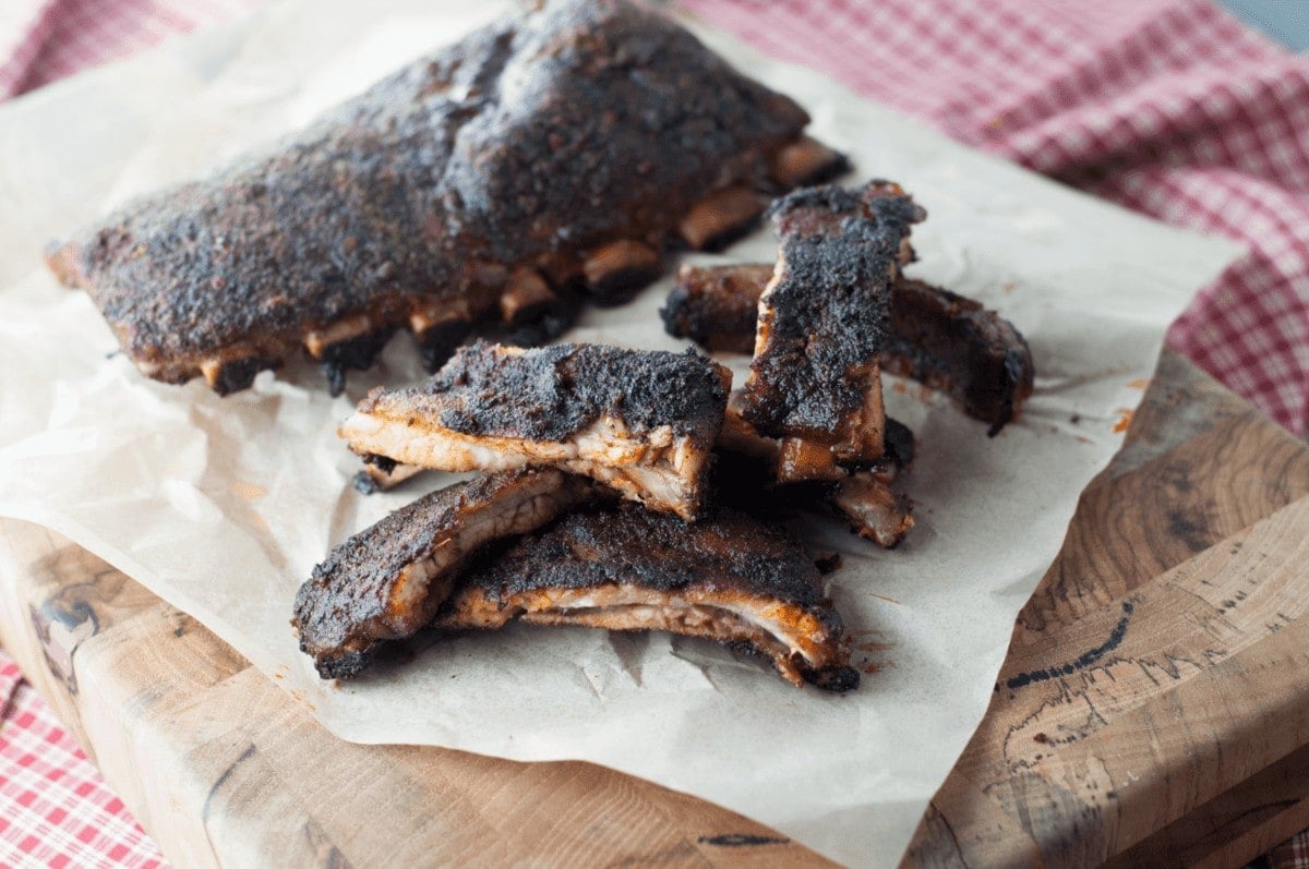 dry rub baby back ribs, sliced and piled high on parchment paper