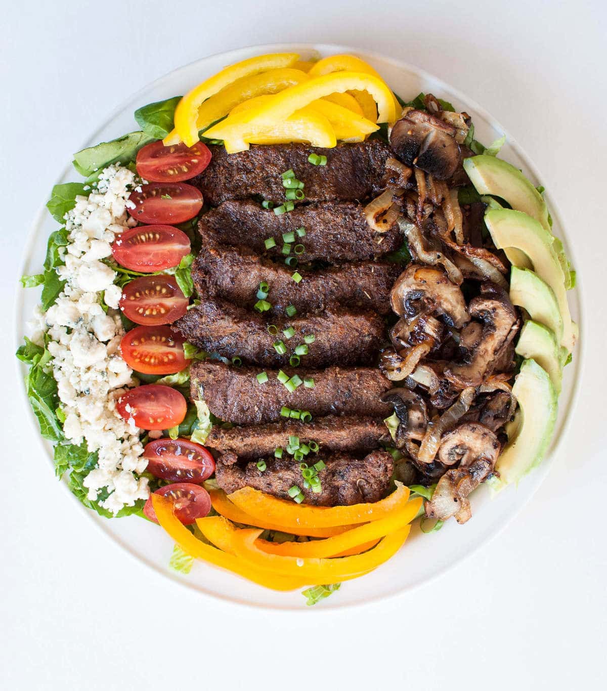 salad with blackened steak, tomatoes, mushrooms, onions, blue cheese, pepper, avocado and lettuce