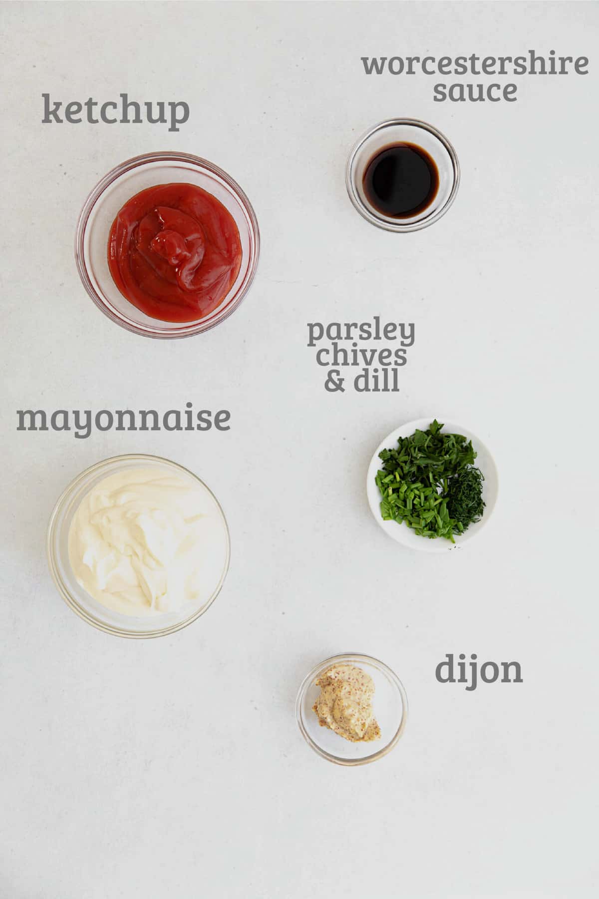 Ingredients for Russian dressing in a white ceramic bowl - ketchup, mayo, dijon, Worcestershire, fresh herbs