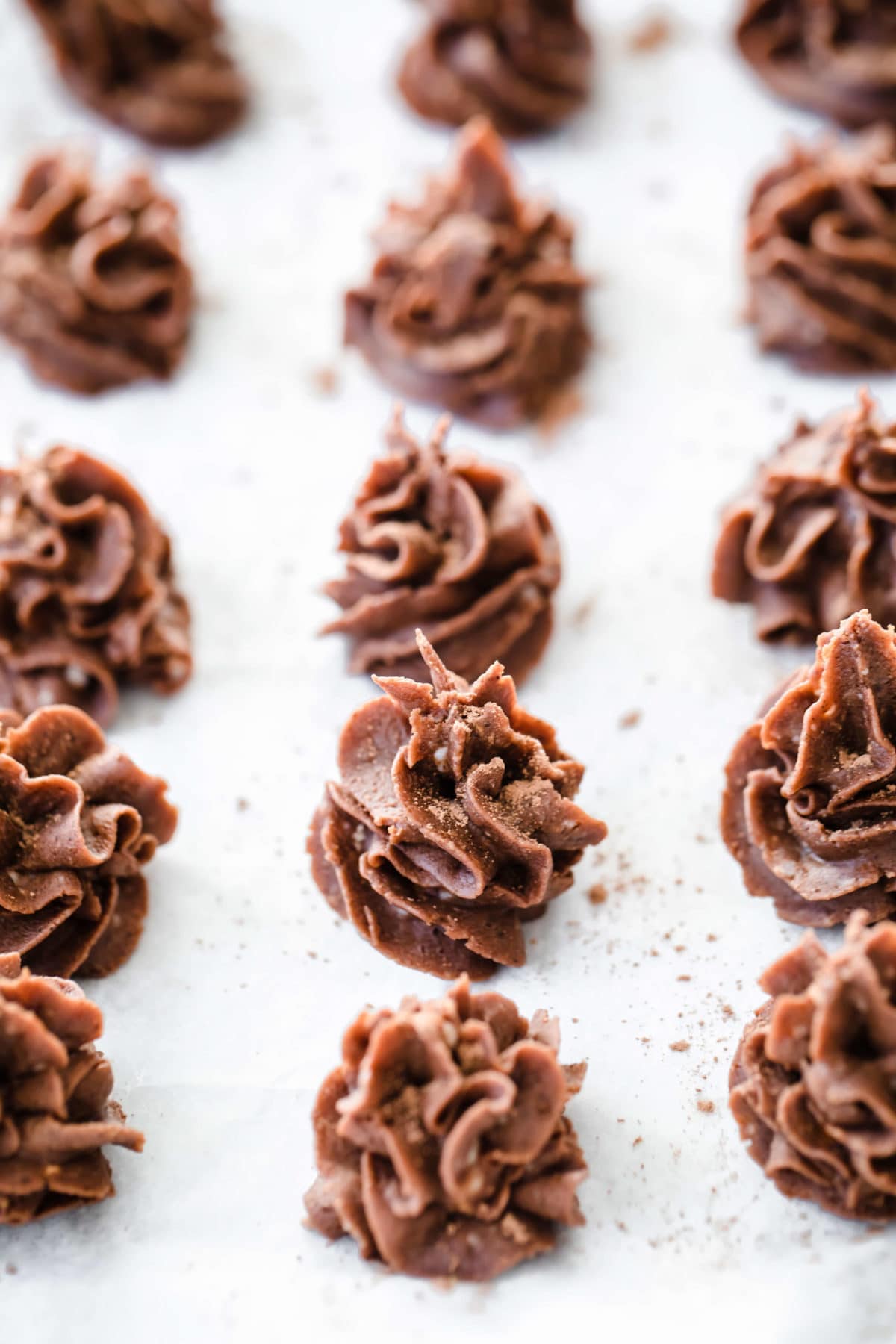 individual chocolate desserts piped onto a parchment lined baking sheet