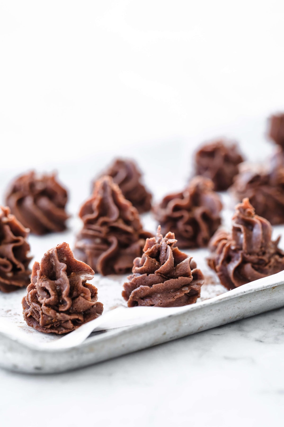 individual chocolate desserts piped onto a parchment lined baking sheet