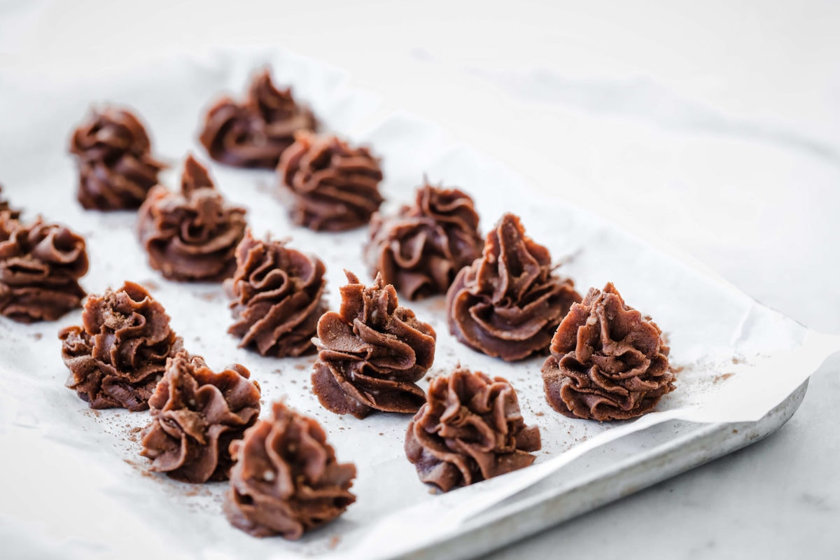 individual chocolate desserts piped onto a parchment lined baking sheet