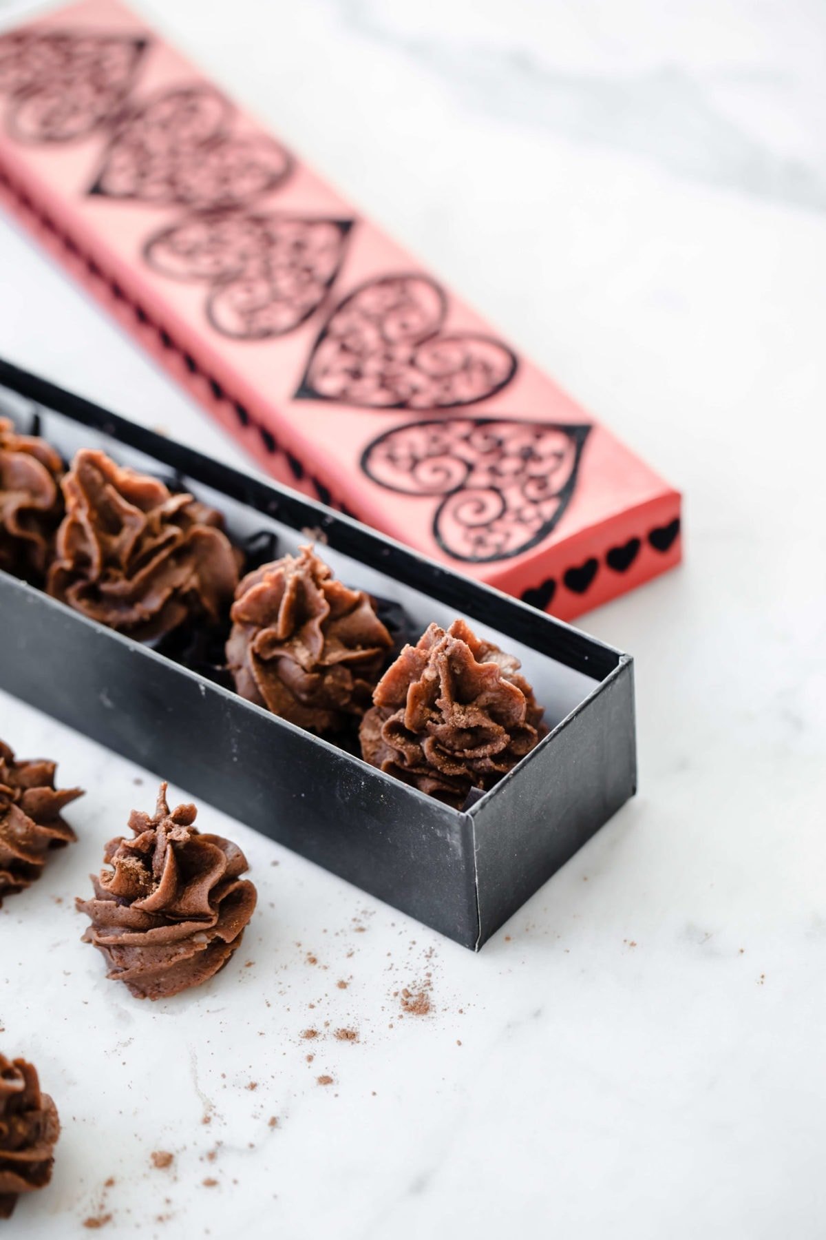 individual chocolate desserts piped into a decorative valentines day candy box