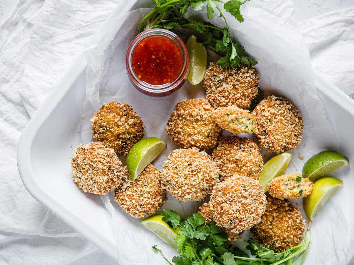 a plate of keto thai shrimp cakes with limes, cilantro and chili sauce