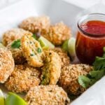 gluten free shrimp cakes plated with sweet chili sauce and limes