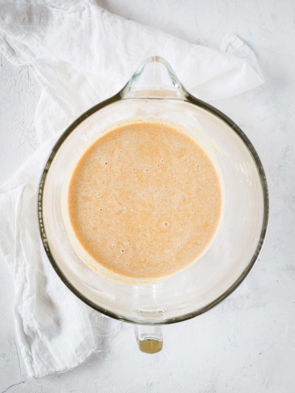 a measuring cup with eggs, pumpkin puree, cream, sweetener and eggs in it, all whisked together. 