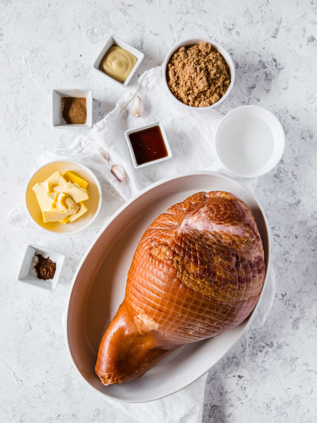 flat lay of all the ingredients to make a keto glazed ham - ham, brown sugar, mustard, molasses, garlic