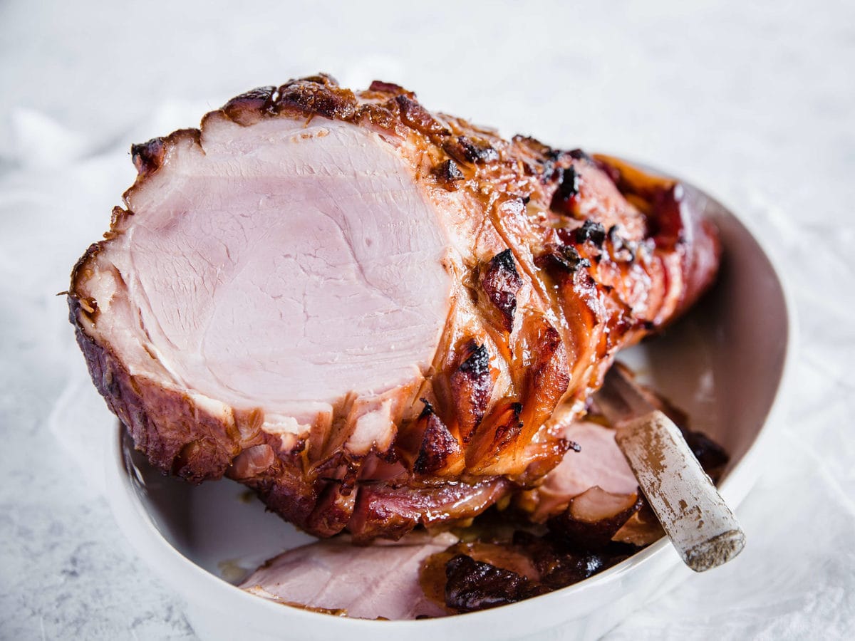 a glazed ham fresh out of the oven, sliced in a serving dish