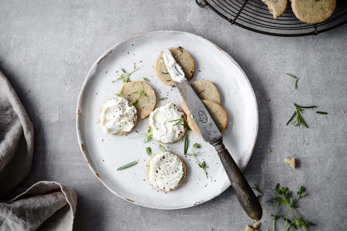 Plate of crunchy keto crackers with cream cheese spread on top