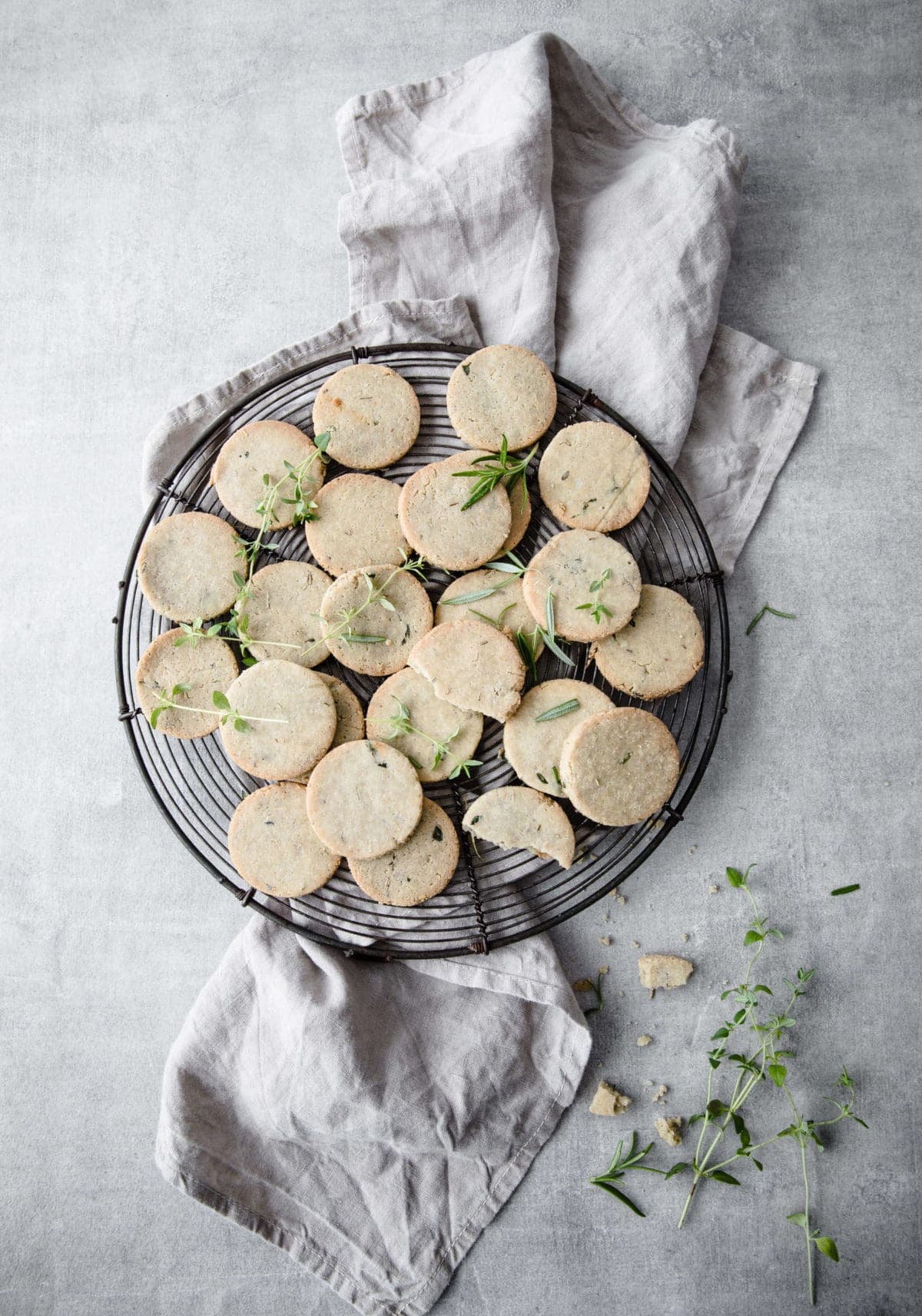 a big plate of keto gluten free crackers surrounded by fresh herbs