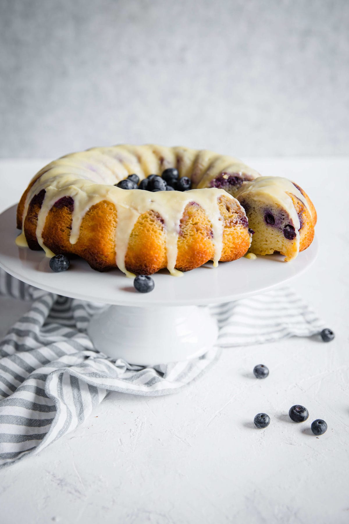 sugar free pound cake on a cake stand with a slice taken out of it