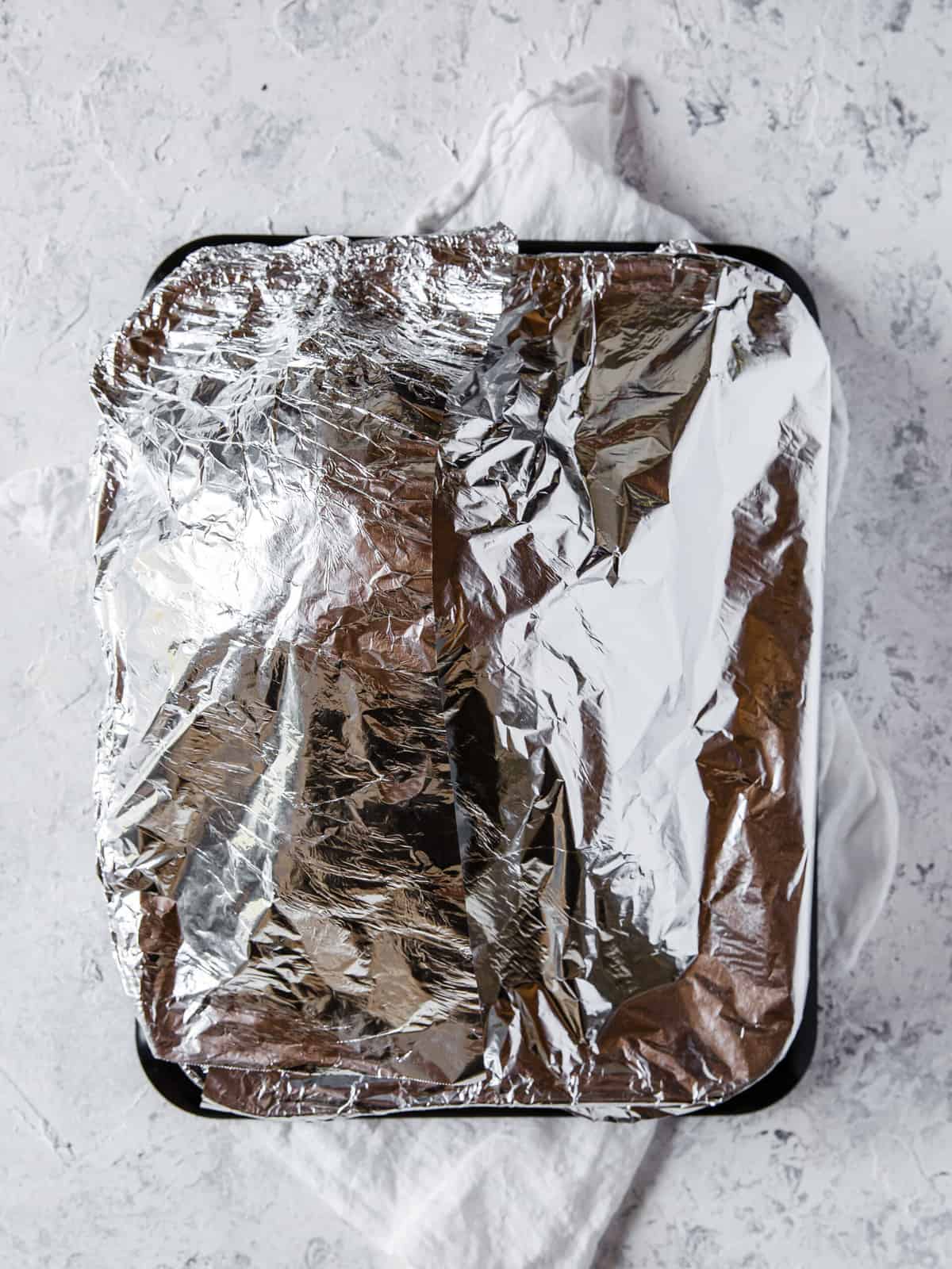 abon-in ham in a disposable aluminum baking dish, wrapped in foil, ready to go into the oven