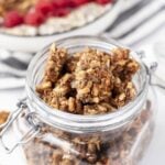 a jar of gluten free granola with fresh fruit and yogurt