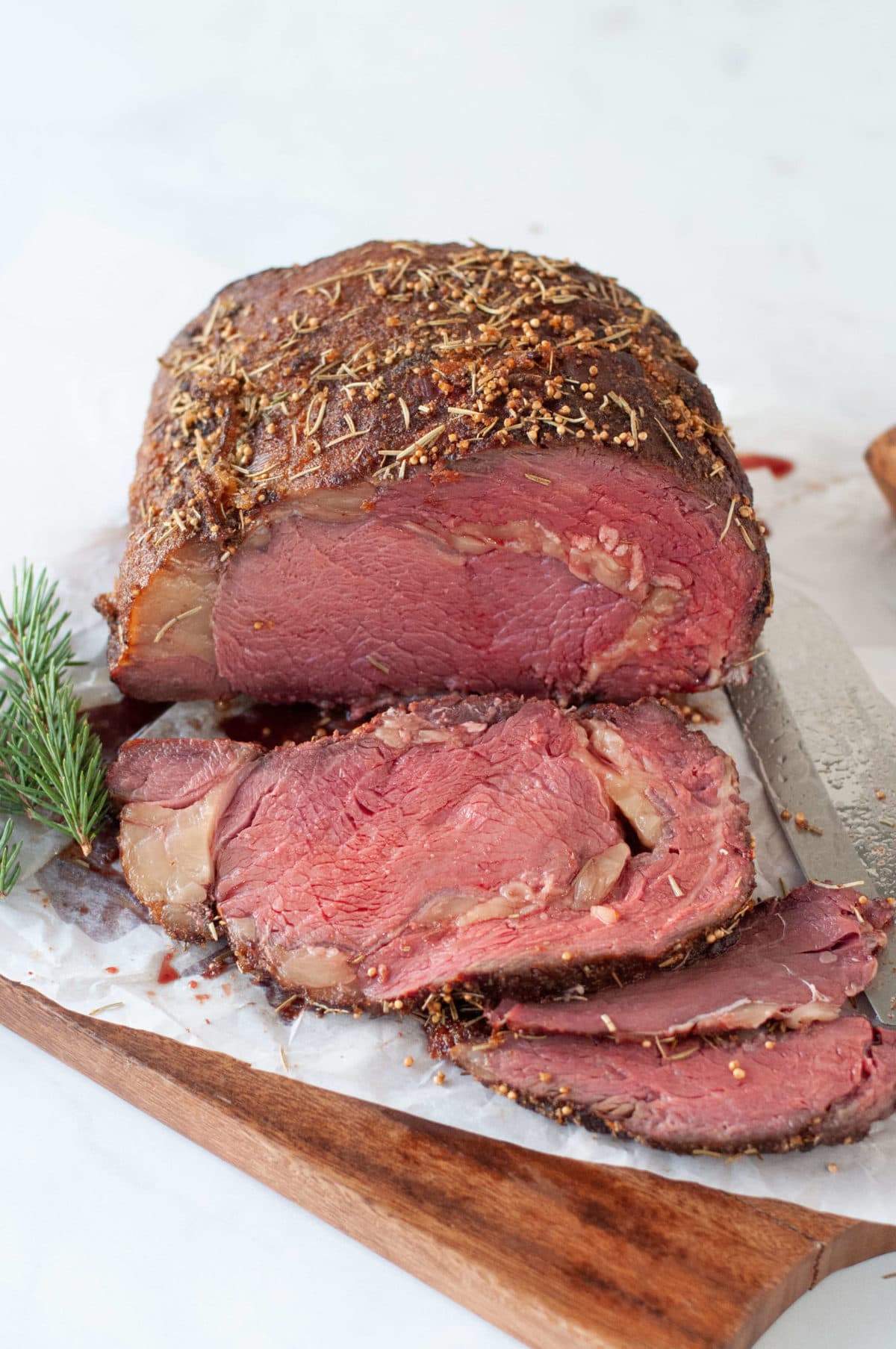 a smoked ribeye roast on a cutting board, sliced into thick steaks