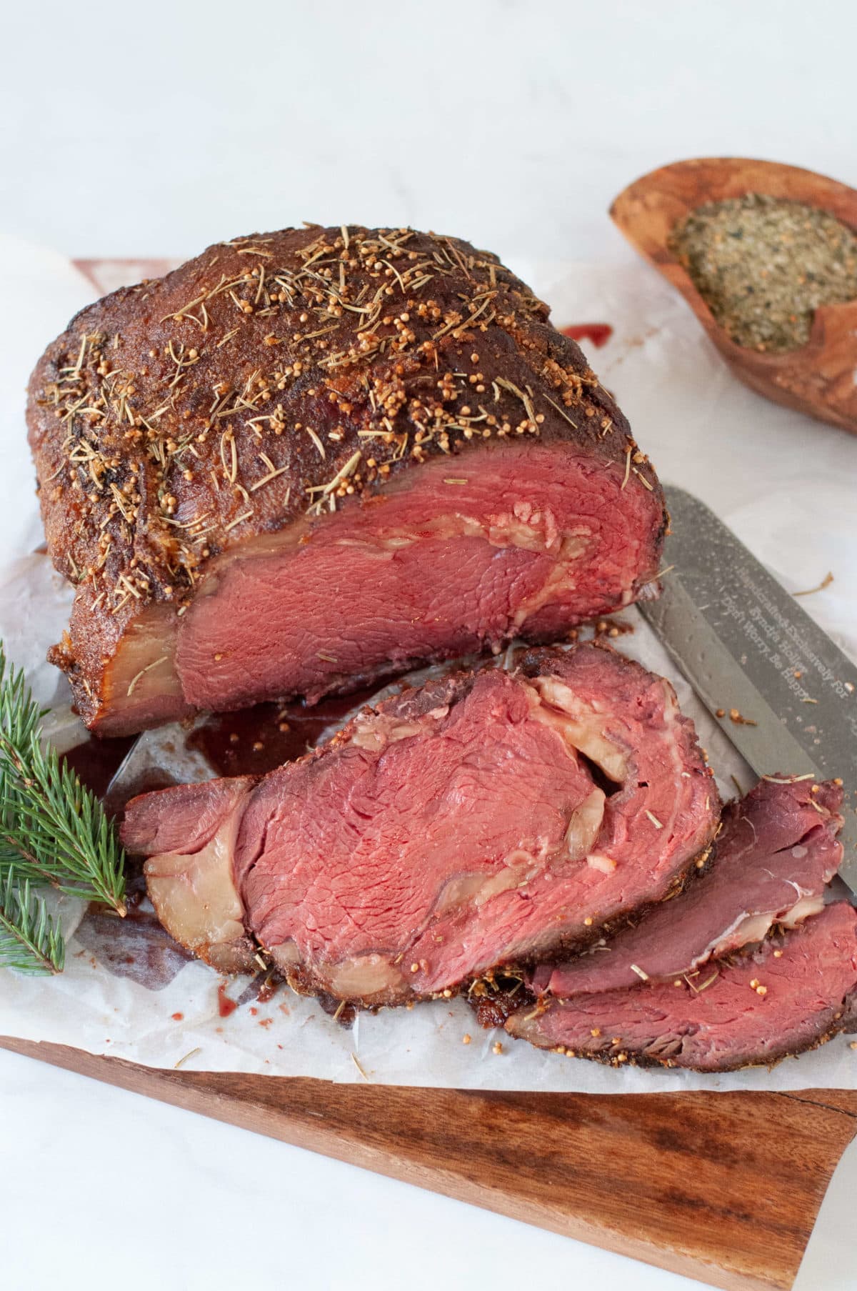 a smoked ribeye roast on a cutting board, sliced into thick steaks