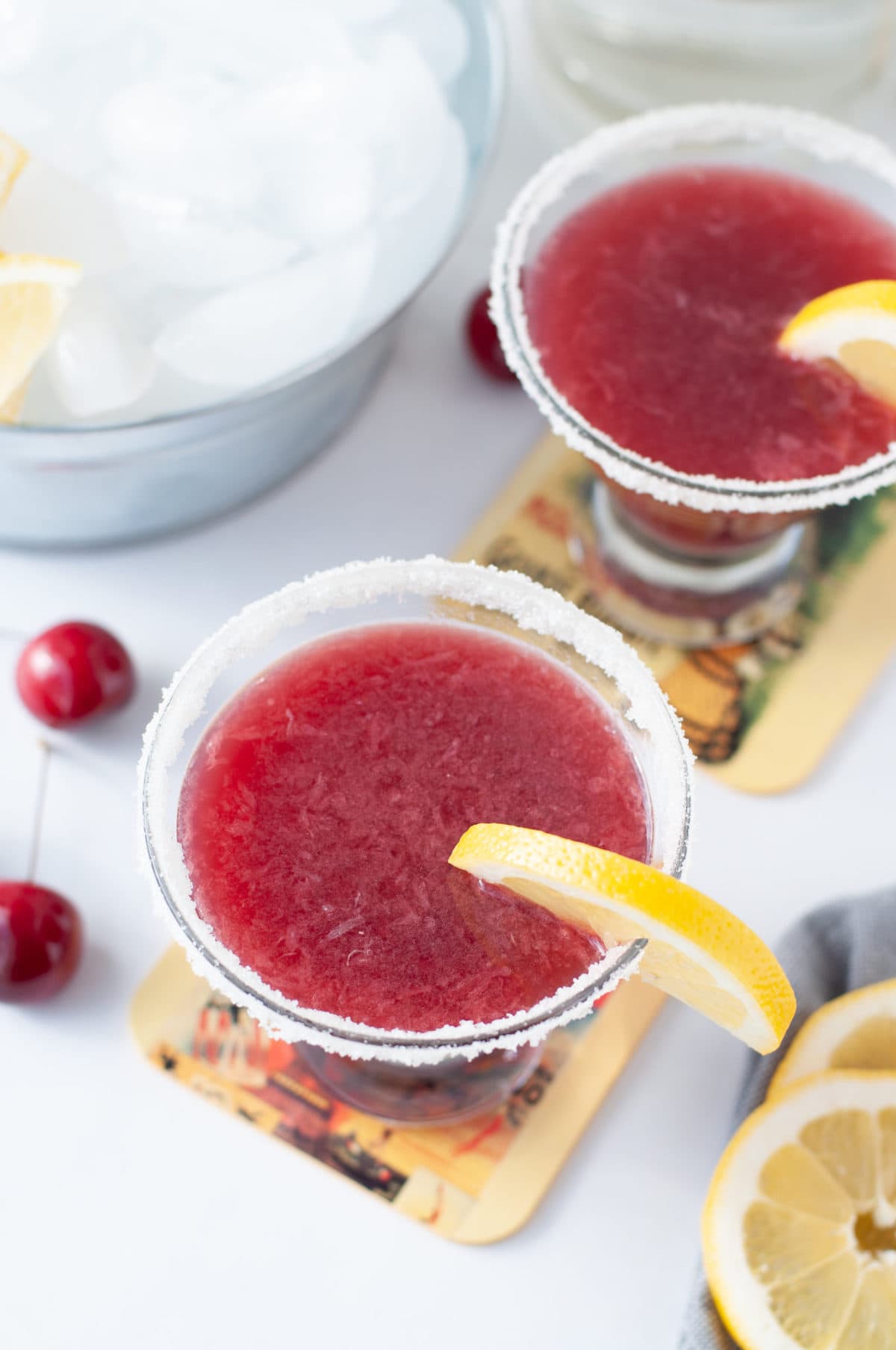 a stemless martini glass filled with a tart cherry lemon drop, garnished with a sugar rim and a lemon