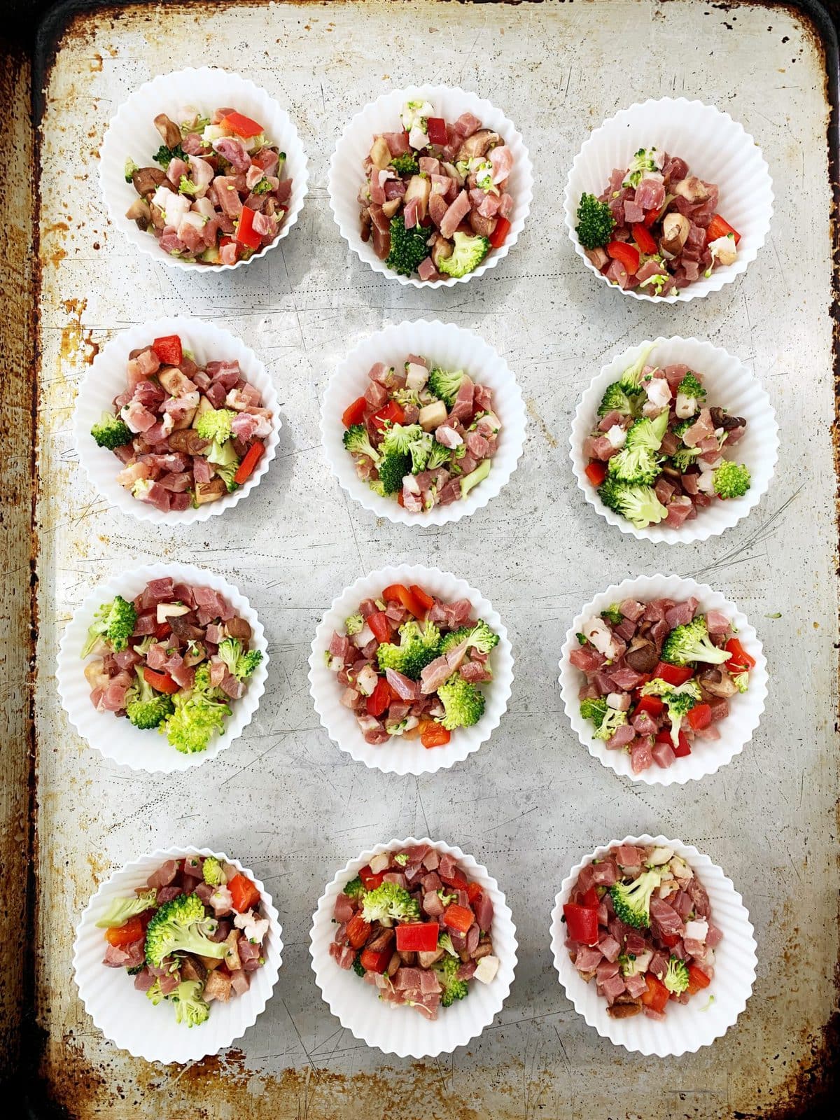 Overhead shot of muffin cups filled with meat and vegetables