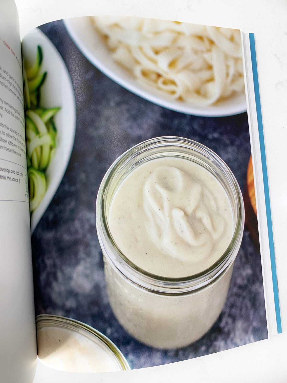flat lay of a dairy free alfredo sauce recipe in a cookbook 