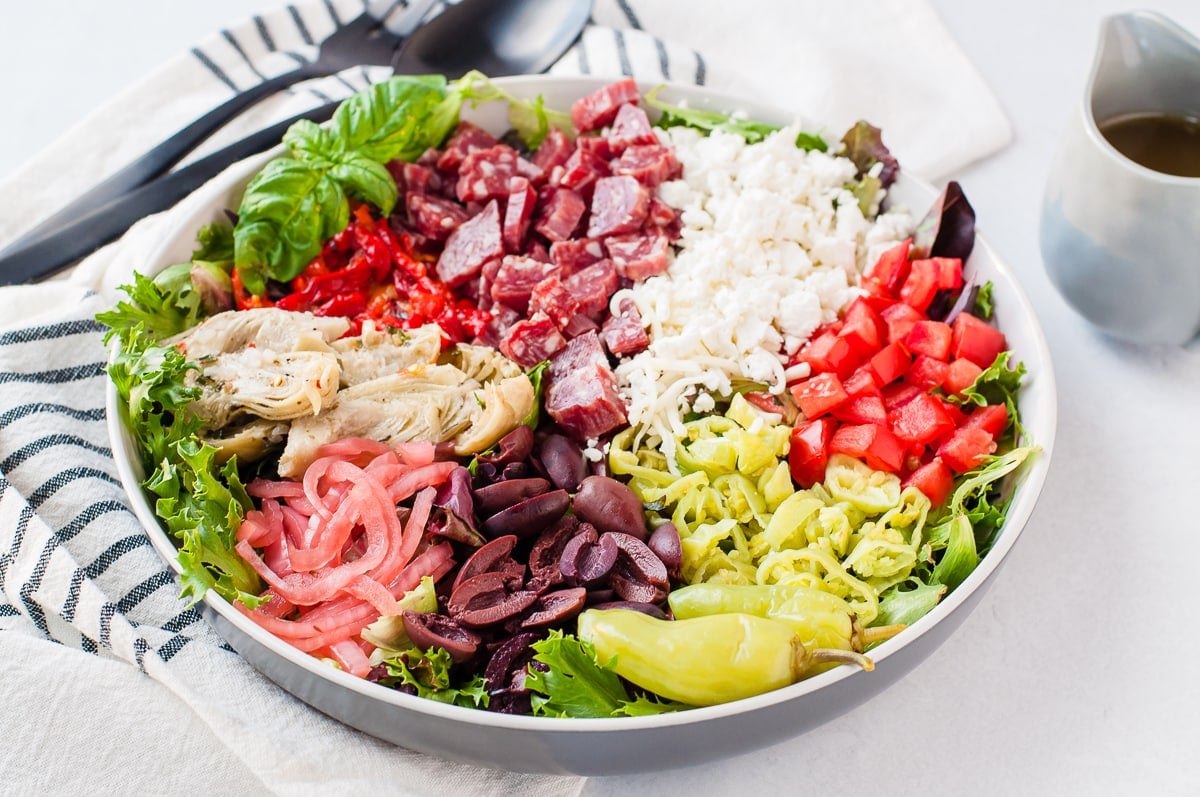 Overhead shot of a brightly colored antipasto salad - topped with meats, cheese, and vegetables