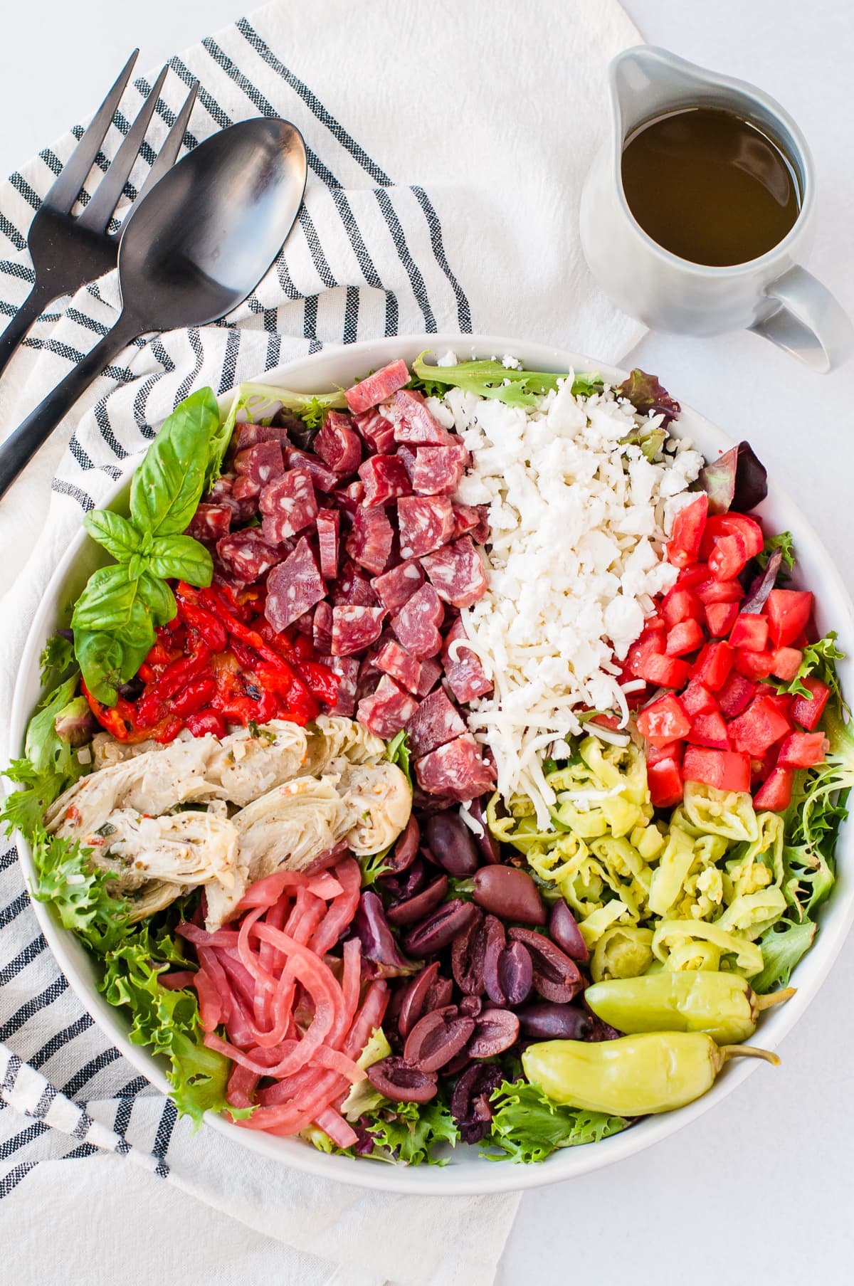 Overhead shot of a brightly colored antipasto salad - topped with meats, cheese, and vegetables