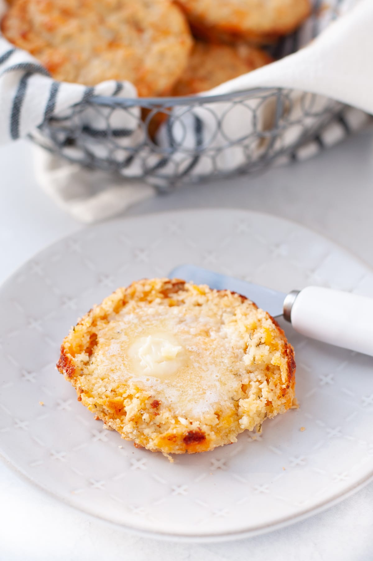 overhead shot of a keto cheddar biscuit slathered with melted butter