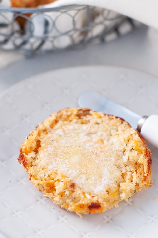 overhead shot of a keto cheddar biscuit slathered with melted butter