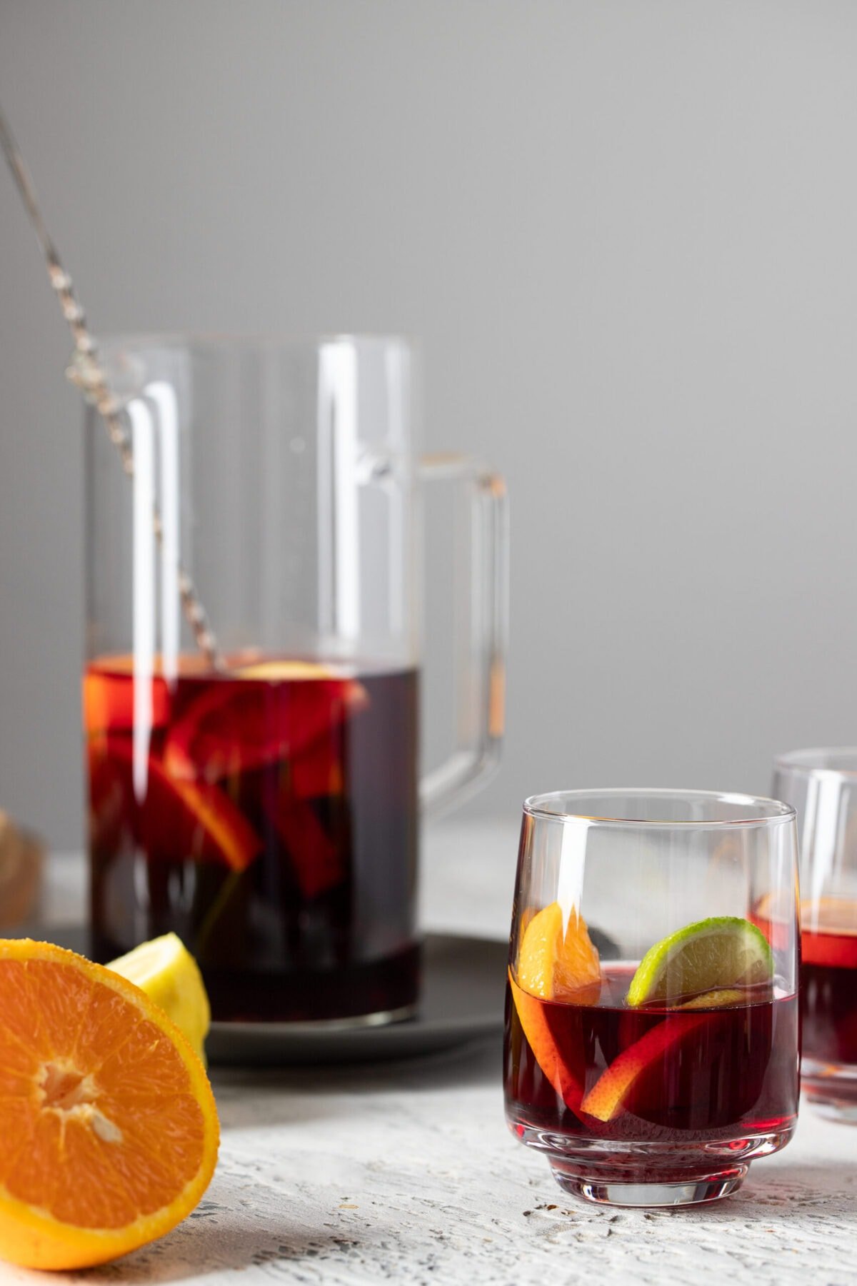 Refreshing pitcher of kombucha Sangria on cement background.