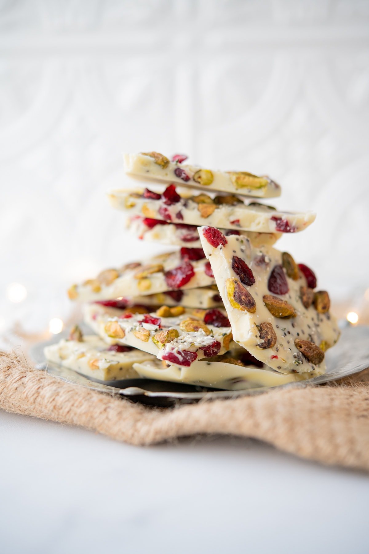 close up of white chocolate bark with nuts, seeds, and cranberries piled high