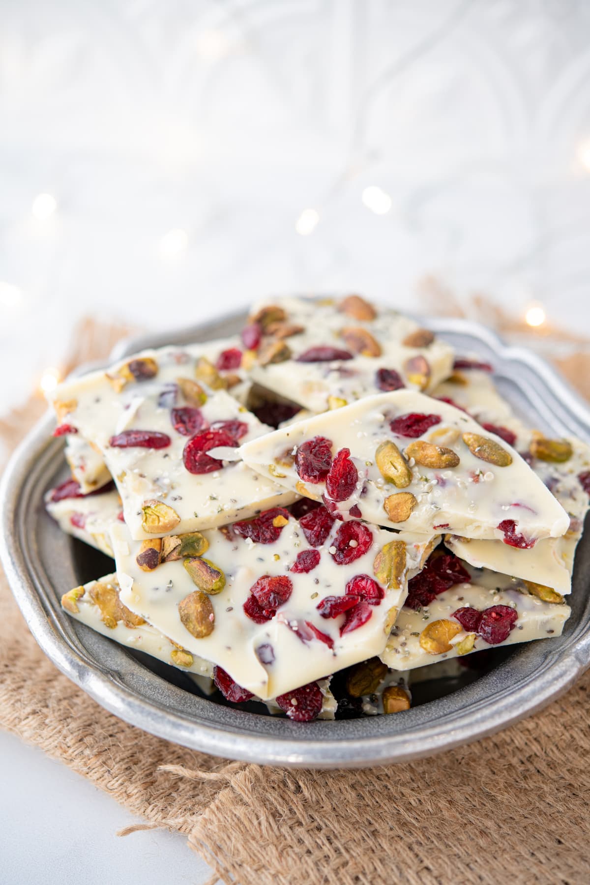 close up of white chocolate bark with nuts, seeds, and cranberries piled high