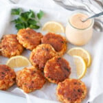 Shrimp cakes surrounded by lemons and parsley, served with remoulade