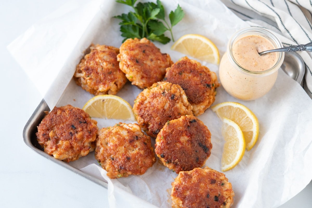 Shrimp cakes surrounded by lemons and parsley, served with remoulade