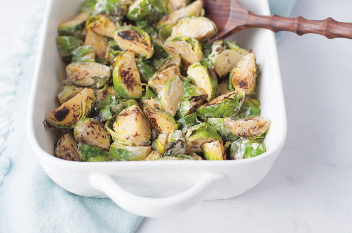 Close up image of Roasted Brussels sprouts in a white baking dish
