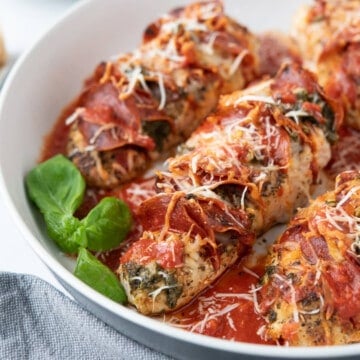 chicken breasts stuffed hasselback style with pizza sauce, pepperoni, cheese, pesto, and fresh basil
