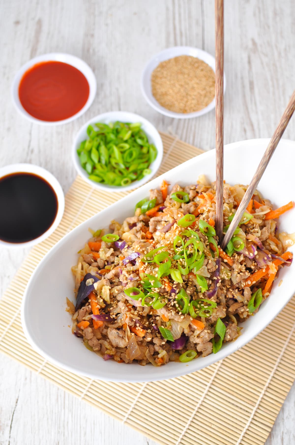 Keto Egg Roll in a Bowl is the perfect quick and easy one pot meal. Juicy ground pork, hearty cabbage, onion, garlic and ginger, sautéed with toasted sesame oil, rice vinegar, and soy sauce, topped with green onions, sesame seeds and sriracha. Best if all it can be ready in less than 30 minutes.